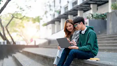 Estudiant utilitzant el seu portàtil per completar la matrícula universitària